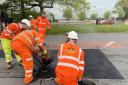 Workers demonstrating the effectiveness of mastic asphalt