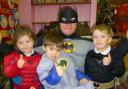 FLYING VISIT: Four-year-olds Illyda Senher, Jack Hurdman and Oscar Griffiths, with Batman, otherwise known as Ash Roberts.