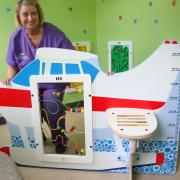 Ward manager Sally Bloomer with the standalone aeroplane which forms part of the new interactive waiting room