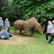 PECULIAR PRESENT: John Walker, right, and wife Janie, with some of the final year pupils who helped to create a wicker rhino statue.