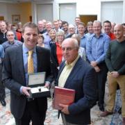 GOLDEN EMPLOYEE: Steve Arnold, front right, receiving a watch and a 50 golden years keepsake book from Chris Akers, managing director. 351414M
