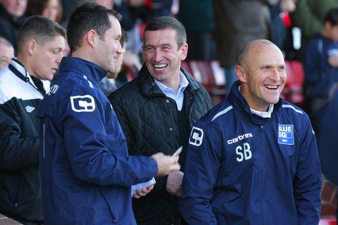 Harriers boss Steve Burr and coach Steve Guinan joke with Newport manager Justin Edinburgh before the game.