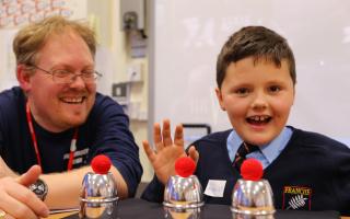 Magician Jay Adkins takes a pupil through a magic trick at the first enrichment workshop afternoon.