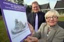 LOOKING BACK: Betty Caswell and Cookley Sebright Primary School headteacher Martin De Vine with Betty's latest village history book. 431407JH