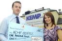 Hitting the target: Tesco manager Mike Burke hands over £1,000 to Kemp Hospice community fundraiser Sam Howell.