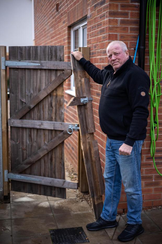 Kidderminster Shuttle: Darrell Meekcom standing by his damaged fence. Photo: SWNS 