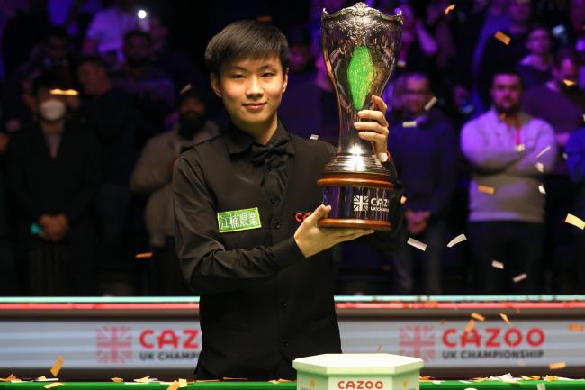 Zhao Xintong lifts the trophy after winning the final of the UK Championship