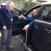 Driver Wynne Williams lends a helping hand to passenger Heather Vick