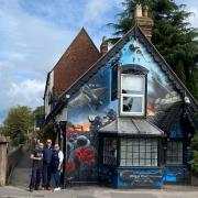 Artist Gareth Way and pub owners Andy and Maria Gooding next to the mural
