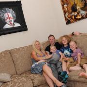 PROUD: Jody Craddock with, from left, wife Shelley and sons Toby, Joseph and Luke, with some of his artwork behind them.